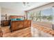 Bright main bedroom with hardwood floors, a large window, and a decorative bed at 1809 Westerham Loop, Trinity, FL 34655