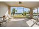 Relaxing sunroom with tile flooring and large windows showcasing serene water views and tropical landscaping at 1809 Westerham Loop, Trinity, FL 34655