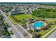 Aerial view showcasing a community pool, clubhouse, green spaces, and well-maintained homes in a planned neighborhood at 1811 Harbour Blue St, Ruskin, FL 33570