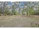 Expansive backyard featuring mature trees, a covered carport, and ample open space at 18606 Kuka Ln, Spring Hill, FL 34610