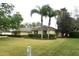 Charming single-story home with a well-manicured lawn and mature palm trees at 19109 Beckett Dr, Odessa, FL 33556