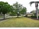Well-maintained front yard featuring lush green grass, mature trees, and a sidewalk at 19109 Beckett Dr, Odessa, FL 33556