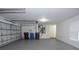 View of the garage with ample space, a closed door, and trash and recycle bins at 19109 Beckett Dr, Odessa, FL 33556