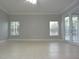 Bright living room featuring tile flooring, two windows, and a glass sliding door at 19109 Beckett Dr, Odessa, FL 33556