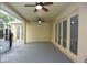 View of the covered patio with two ceiling fans and French doors to enter the home at 19109 Beckett Dr, Odessa, FL 33556