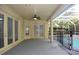 View of the covered patio with a ceiling fan, French doors, and safety fence around the pool at 19109 Beckett Dr, Odessa, FL 33556