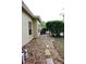 Side yard area with stone pathway, landscaping and partial view of the home's exterior at 19109 Beckett Dr, Odessa, FL 33556