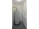 Water heater in a small room with a window, piping, and grey floors at 19109 Beckett Dr, Odessa, FL 33556