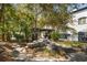 The tranquil backyard features a stone patio, shaded pergola and lush landscape for relaxing at 200 Grand Blvd, Tarpon Springs, FL 34689