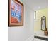 Bright hallway features a statement art piece and a stylish mirror reflecting natural light from the accent window at 200 Grand Blvd, Tarpon Springs, FL 34689