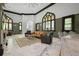 A spacious living room area featuring stained glass windows, a seating area, and black accents at 200 Grand Blvd, Tarpon Springs, FL 34689