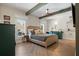 Spacious main bedroom with hardwood floors, ceiling beams, neutral decor, and plenty of natural light at 200 Grand Blvd, Tarpon Springs, FL 34689