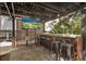 Outdoor bar area with barstool seating and mounted television for outdoor entertaining at 200 Grand Blvd, Tarpon Springs, FL 34689