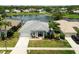 Stunning aerial view of a lakeside home with a screened lanai and lush landscaping, situated in a desirable neighborhood at 22129 Yachtclub Ter, Land O Lakes, FL 34639