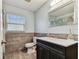 Bathroom featuring tiled walls, black vanity with a white countertop, and a silver-framed mirror at 22129 Yachtclub Ter, Land O Lakes, FL 34639