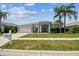 Charming single-story home featuring a well-manicured lawn, mature palm trees, and a welcoming entrance at 22129 Yachtclub Ter, Land O Lakes, FL 34639