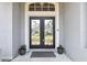 Elegant front door with decorative glass, complemented by potted plants, creating a warm and inviting entry at 22129 Yachtclub Ter, Land O Lakes, FL 34639
