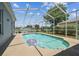 Screened-in pool area featuring a beautiful pool with a view of the lake and landscaping at 22129 Yachtclub Ter, Land O Lakes, FL 34639
