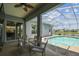 Inviting screened-in pool area with comfortable seating, perfect for outdoor relaxation and entertaining with lake views at 22129 Yachtclub Ter, Land O Lakes, FL 34639