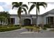 Charming clubhouse entrance with palm trees, beautiful landscaping, and inviting walkway at 2333 Feather Sound Dr # A208, Clearwater, FL 33762