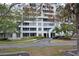Exterior view of a condo building surrounded by lush, tropical landscaping at 2333 Feather Sound Dr # A208, Clearwater, FL 33762