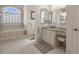 Bathroom featuring a soaking tub, vanity with granite countertop and decorative window at 2375 Fairskies Dr, Spring Hill, FL 34606