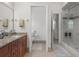 Bathroom with dual sink vanity, granite countertops, wood cabinets, and glass door enclosed shower at 2375 Fairskies Dr, Spring Hill, FL 34606