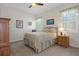 Cozy bedroom features a plush bed, ceiling fan, and bright windows with shutters and decorative curtains at 2375 Fairskies Dr, Spring Hill, FL 34606