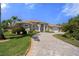 Stunning single-story house with a paved driveway surrounded by lush greenery and palm trees at 2375 Fairskies Dr, Spring Hill, FL 34606