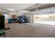 Spacious garage with carpet flooring and a golf cart parked inside with an open overhead door at 2375 Fairskies Dr, Spring Hill, FL 34606