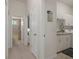 Bright hallway leading to bathroom and laundry room with modern white cabinetry at 2375 Fairskies Dr, Spring Hill, FL 34606