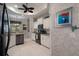 Open kitchen features granite countertops, black appliances, and white cabinets with a ceiling fan at 2375 Fairskies Dr, Spring Hill, FL 34606