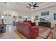 Open-concept living room with tile floor, hardwood accent, comfortable seating, and natural light at 2375 Fairskies Dr, Spring Hill, FL 34606