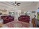 Spacious living room with hardwood floors, comfortable red leather seating and views into the kitchen at 2375 Fairskies Dr, Spring Hill, FL 34606