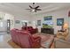Cozy living room featuring a ceiling fan, fireplace, hardwood floors and comfortable red leather seating at 2375 Fairskies Dr, Spring Hill, FL 34606