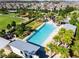 Community pool and amenity center surrounded by manicured lawns and palm trees at 2596 Whittler Br, Odessa, FL 33556