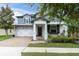 Charming two-story home with a landscaped front yard, covered entryway, and brick-paved driveway leading to a two-car garage at 2596 Whittler Br, Odessa, FL 33556