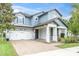 Inviting two-story home showcasing a brick driveway, covered entryway, and meticulously landscaped front yard at 2596 Whittler Br, Odessa, FL 33556