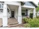 Inviting front porch with classic columns, brick-paved steps, and decorative landscaping at 2596 Whittler Br, Odessa, FL 33556