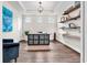 Bright home office with custom shelving, hardwood floors, and a comfortable sitting area at 2596 Whittler Br, Odessa, FL 33556