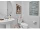 Well-lit powder room with pedestal sink and decorative artwork at 2596 Whittler Br, Odessa, FL 33556
