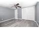Bright bedroom featuring a ceiling fan, wood-look floors, and closet with sliding doors at 2620 Baltic Pl, Holiday, FL 34691
