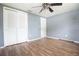 Bedroom offers wood-look floors, a ceiling fan, and a closet with sliding doors at 2620 Baltic Pl, Holiday, FL 34691