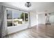 Bright living room with wood-look floors, ceiling fan, and large window allowing ample natural light at 2620 Baltic Pl, Holiday, FL 34691