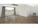 Bright living room with wood-look floors, ceiling fan, and large window allowing ample natural light at 2620 Baltic Pl, Holiday, FL 34691