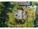 An overhead aerial showcases the home with a screened pool and yard, surrounded by mature trees within the property line at 2628 Shipston Ave, New Port Richey, FL 34655