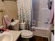 Bathroom featuring a sink, toilet, combination tub/shower, and leaf-patterned shower curtain at 34135 Brown Bayou, Wesley Chapel, FL 33543