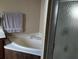 This bathroom features a corner tub, shower with glass door, and a gray towel hanging nearby at 34135 Brown Bayou, Wesley Chapel, FL 33543