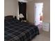 This bedroom boasts a bed with a plaid comforter and a view into the en suite bath at 34135 Brown Bayou, Wesley Chapel, FL 33543