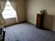 Sunlit bedroom featuring neutral carpet, a dark wood dresser, and a large window at 34135 Brown Bayou, Wesley Chapel, FL 33543